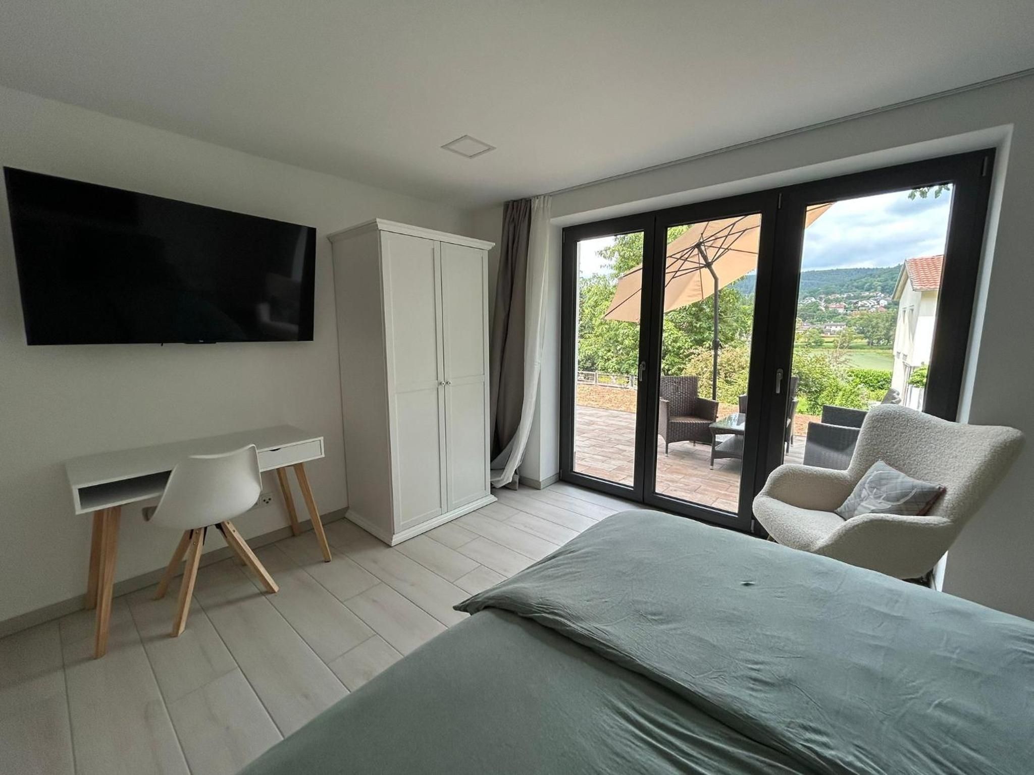 Doppelzimmer mit Blick über das Bett auf Terrasse und Maintal